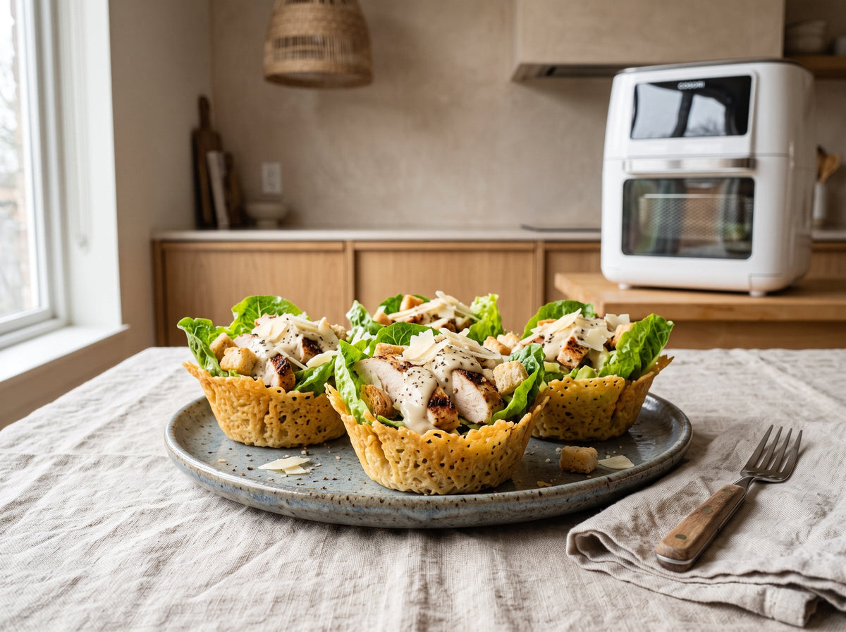 Chicken Caesar Cups aus dem Airfryer – angerichtet auf einem Steingutteller, im Hintergrund eine Heißluftfritteuse